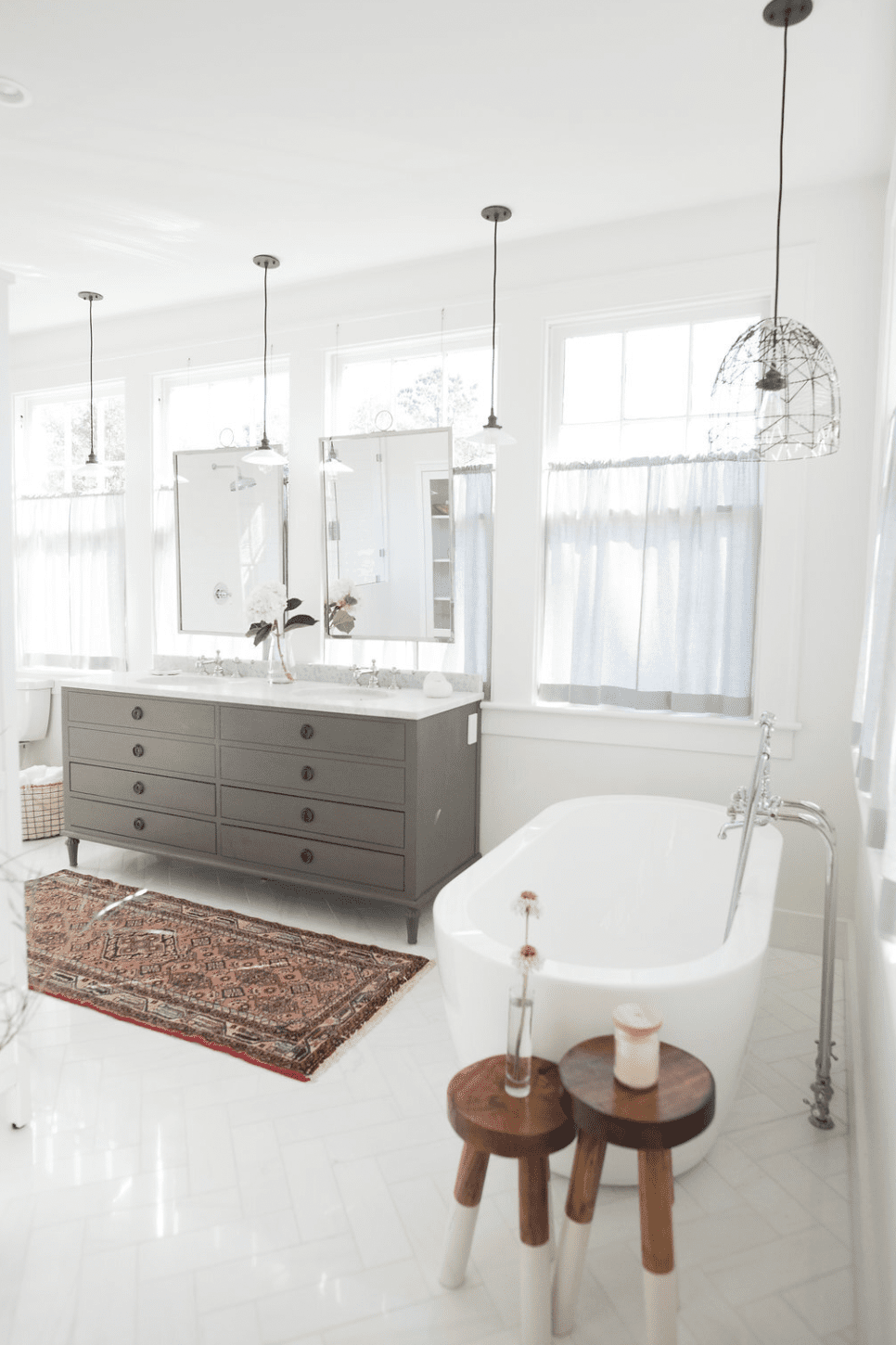 Baignoire blanche avec tabourets en bois à côté