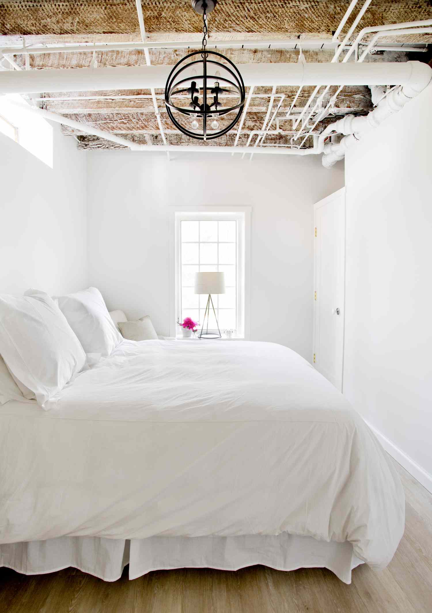chambre d'amis lumineuse avec lustre circulaire