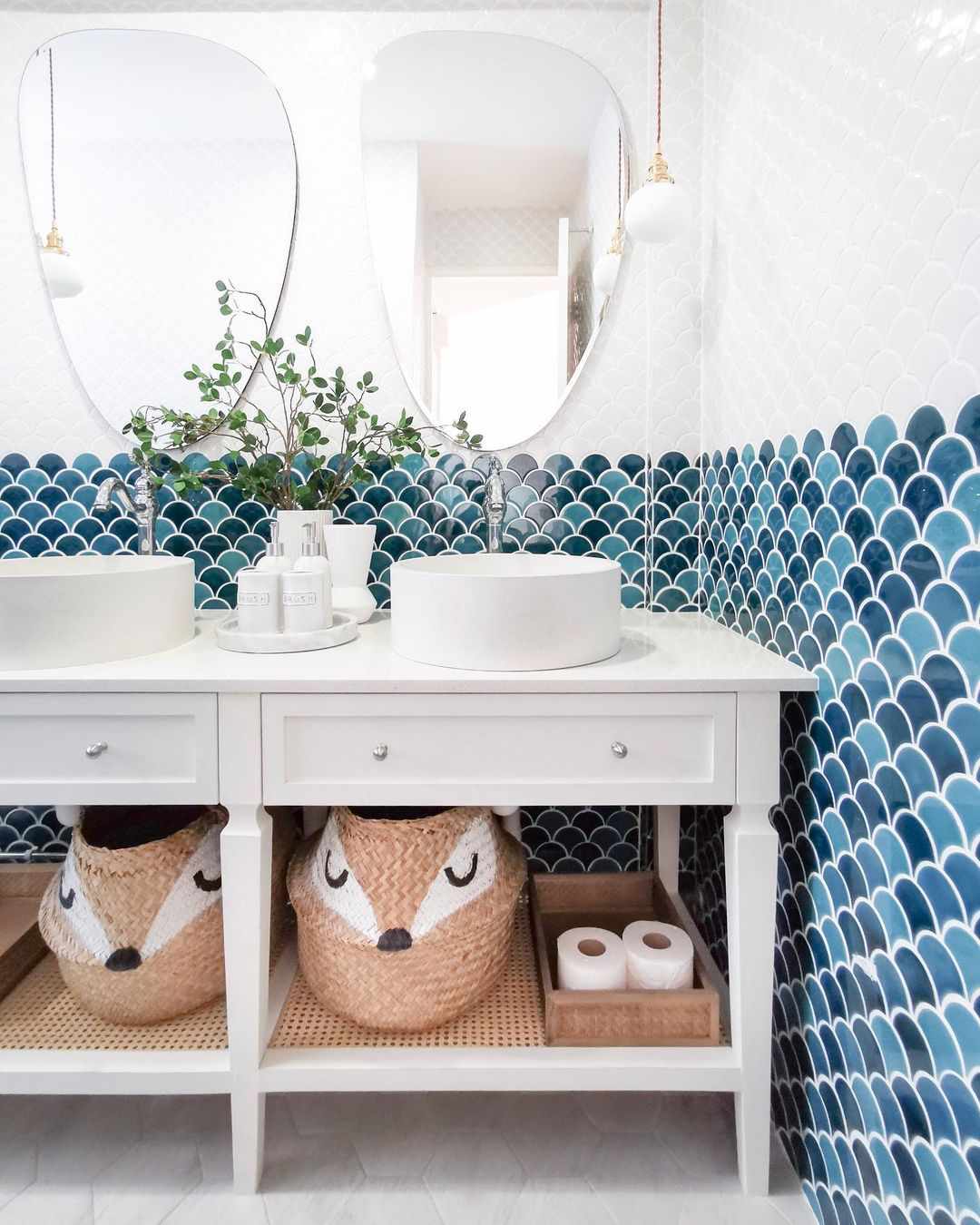 Salle de bain pour enfants avec des paniers de rangement fantaisistes sur l'étagère du meuble-lavabo ouvert.