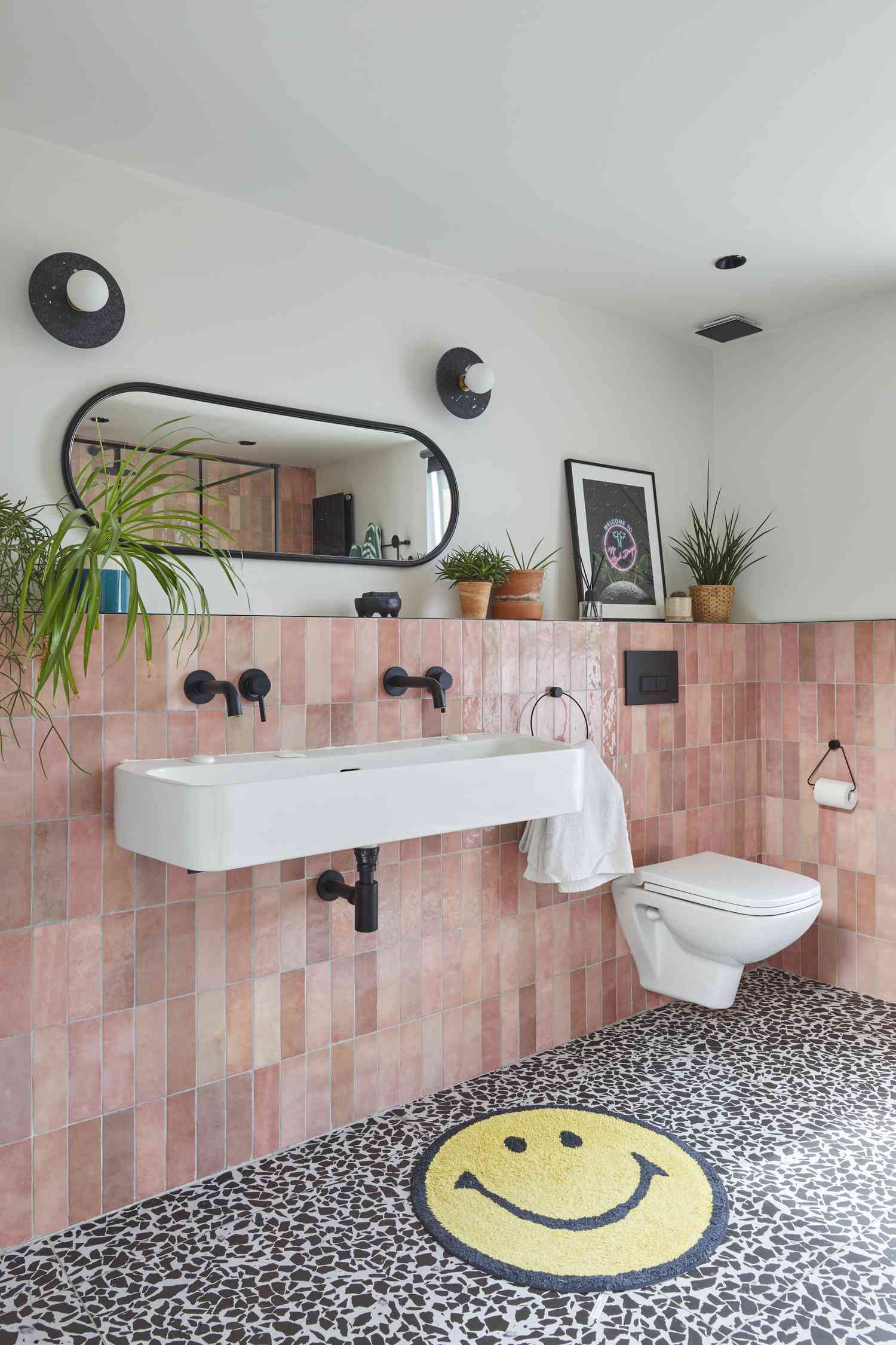 Carrelage rose et sol noir et blanc dans une salle de bain