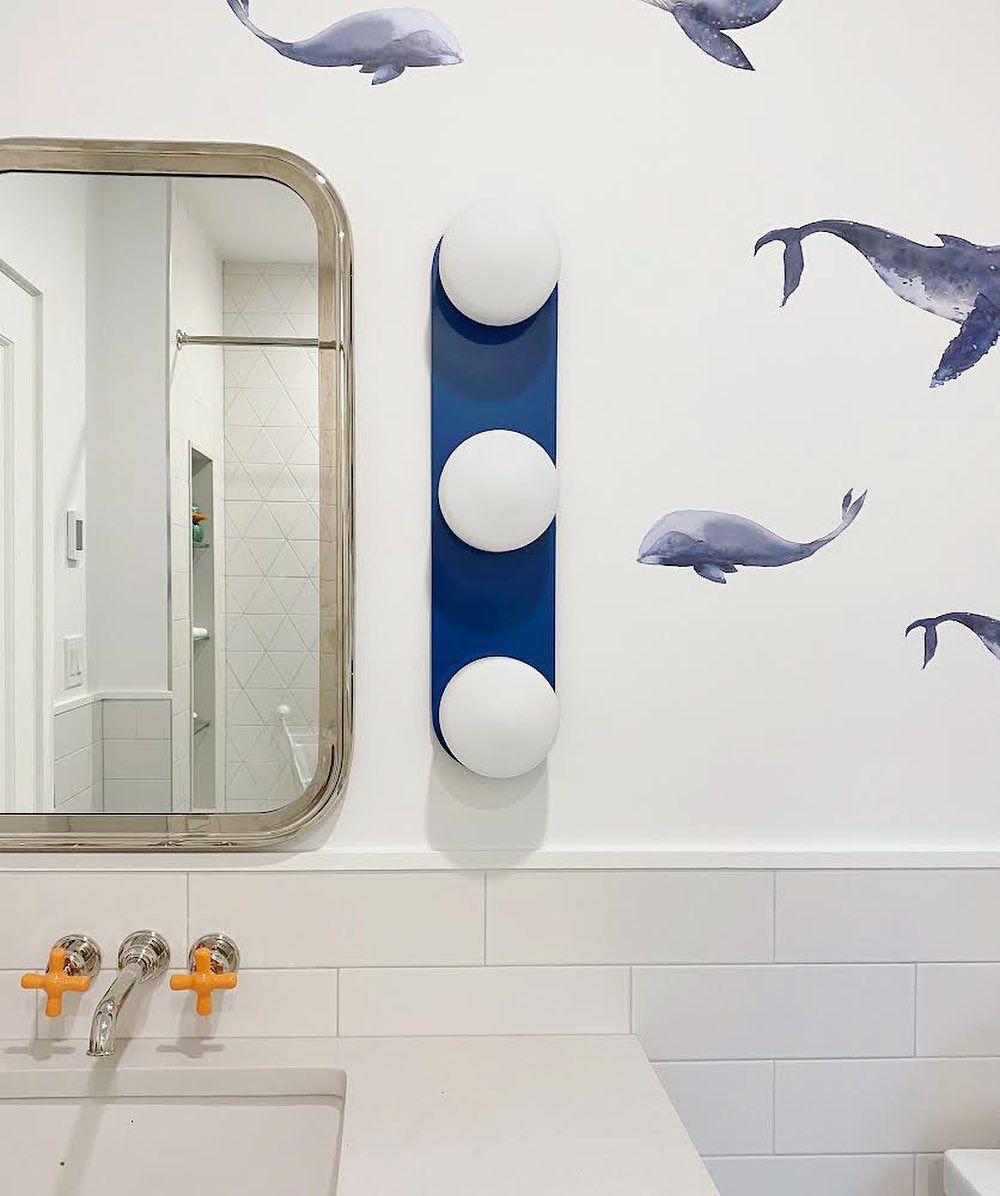Papier peint baleine et luminaire bleu dans la salle de bain