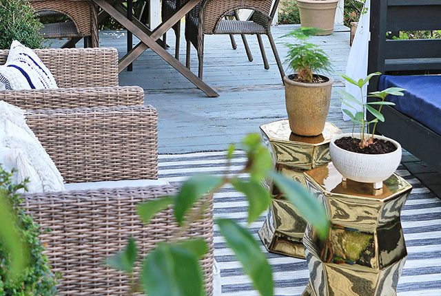 Plantes en pot sur des tabourets de jardin dorés sur un patio
