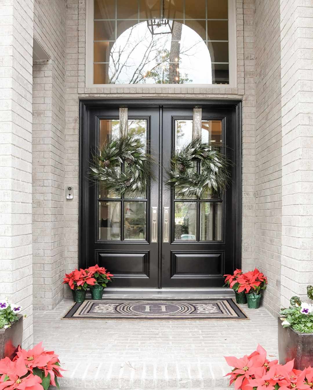 Portes noires avec poinsettias et couronnes