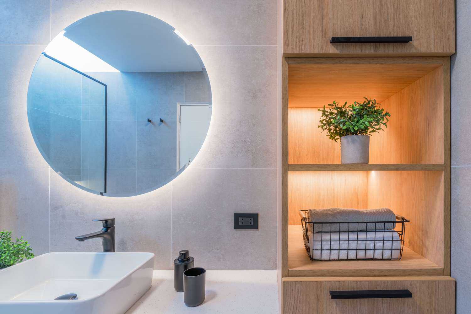 Salle de bain moderne avec éclairage LED sur le miroir et dans les étagères
