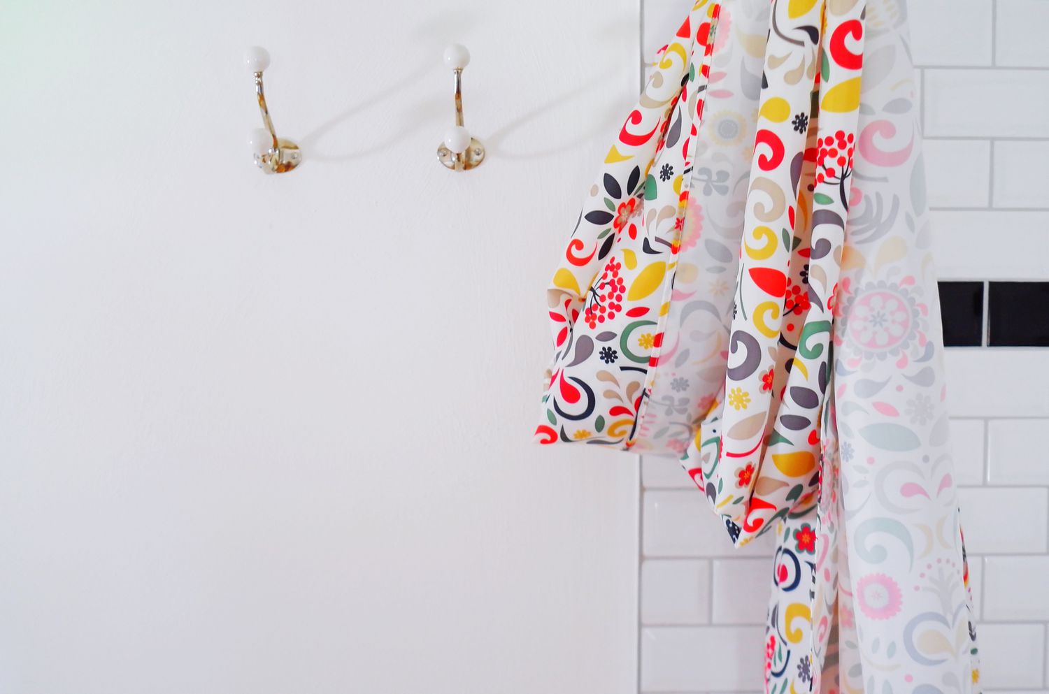 Gros plan sur un rideau de douche multicolore accroché au mur