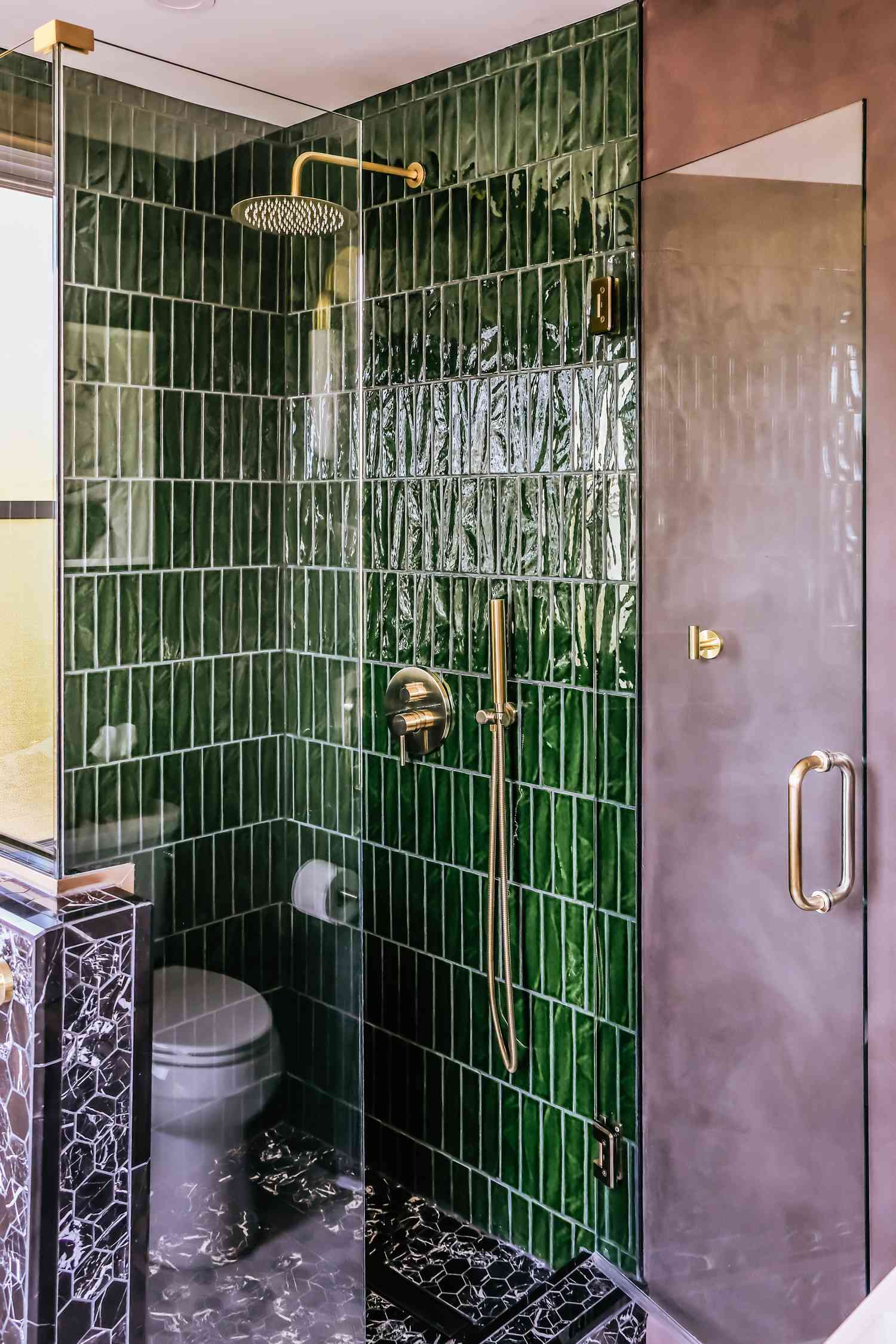 Douche avec carrelage vert et noir.