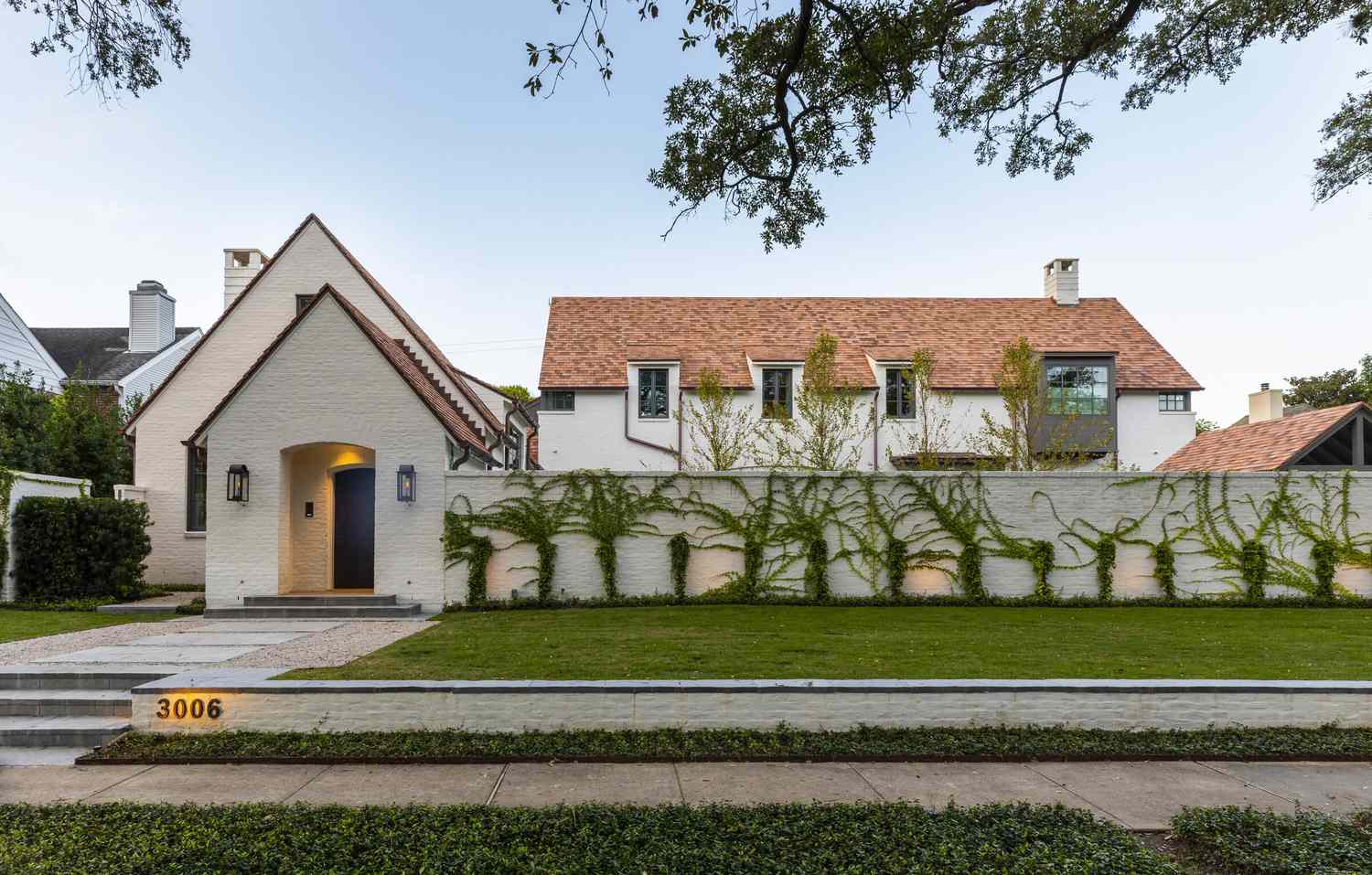 Maison blanche dont le portail est recouvert de lierre vert
