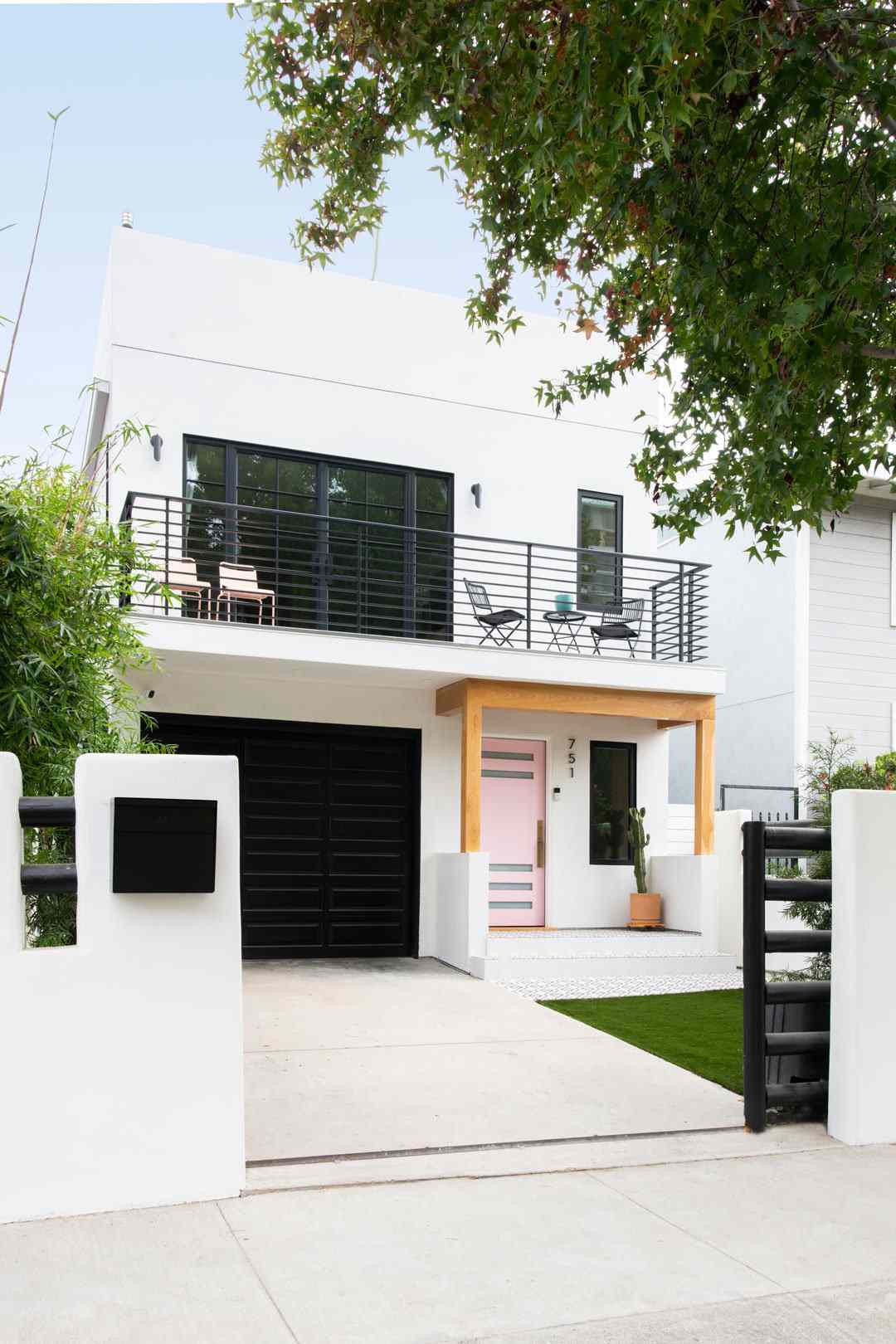Maison blanche et noire avec porte rose