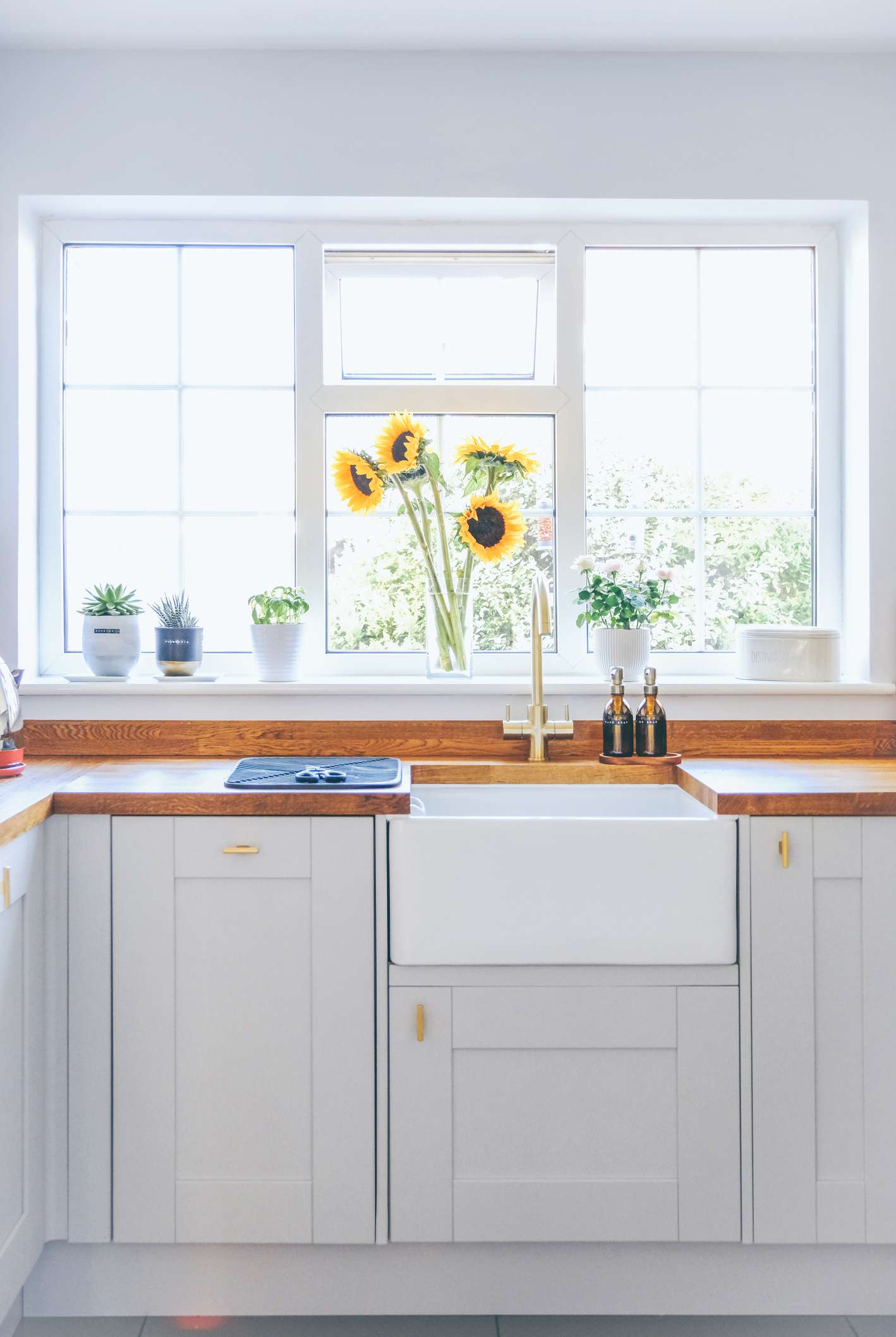 Cuisine moderne et lumineuse avec plan de travail en bois et lave-vaisselle caché