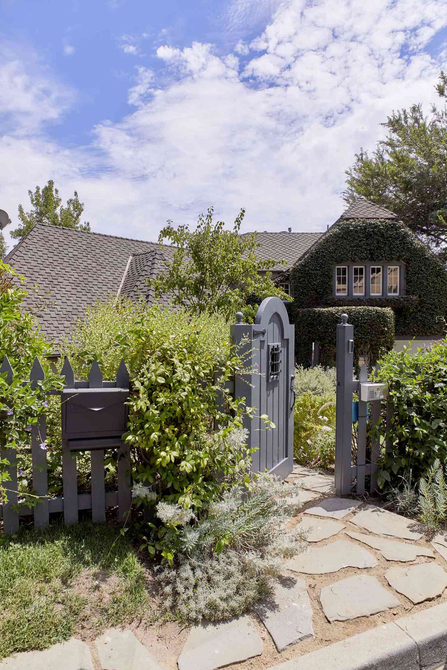 Maison avec clôture en piquets peinte en gris