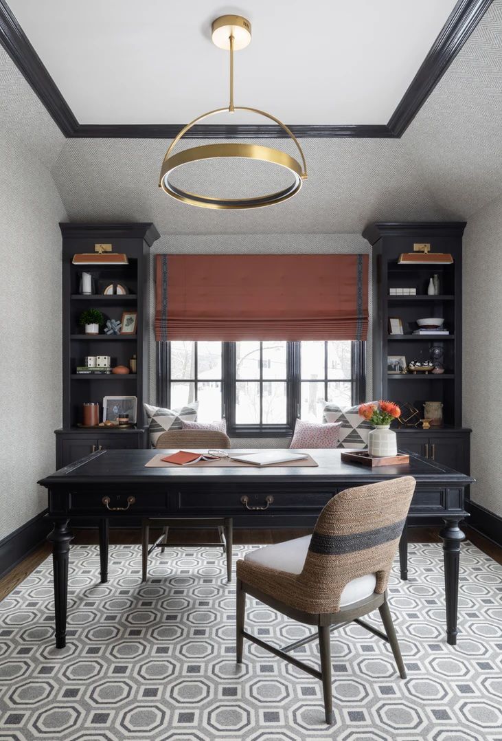 Plafonnier moderne en laiton dans un bureau avec un bureau noir et des éléments encastrés.