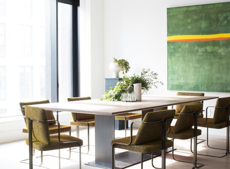Salle à manger blanche avec de grandes œuvres d'art vertes.