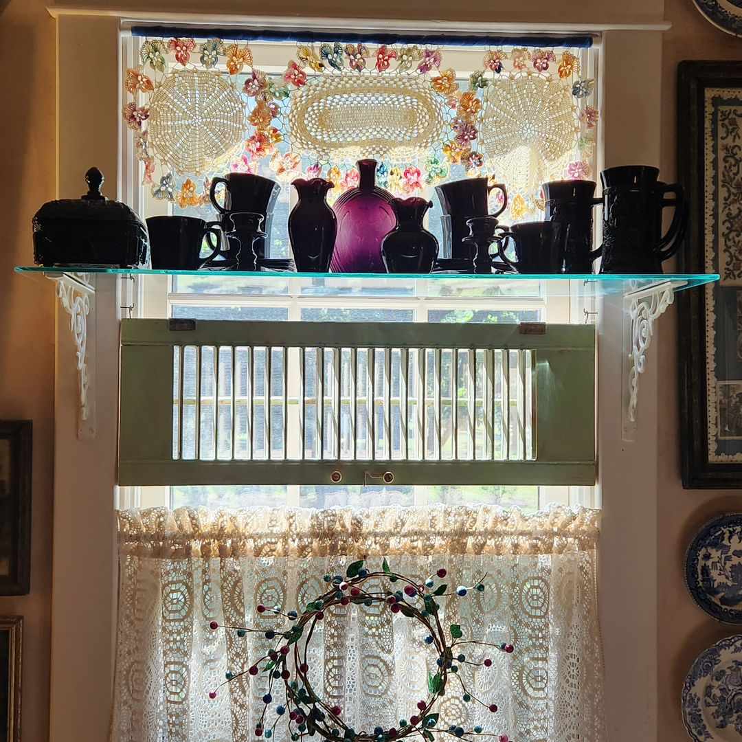 collection de vases présentée au-dessus d'une fenêtre