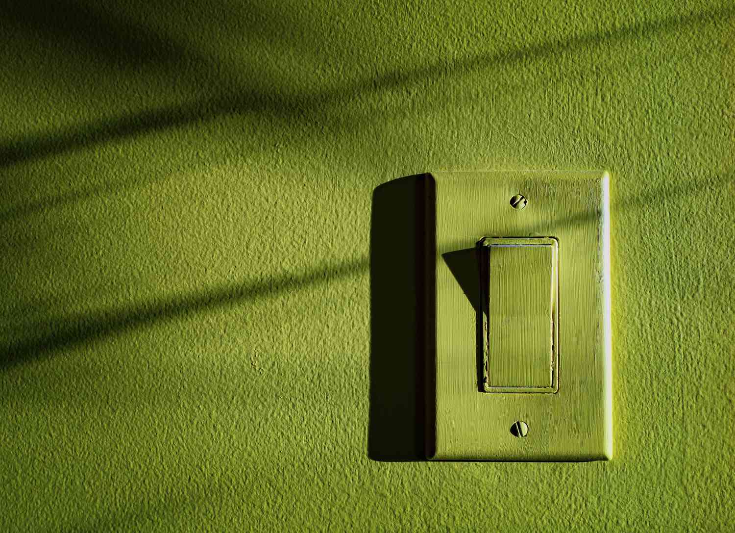 interrupteur peint sur un mur vert