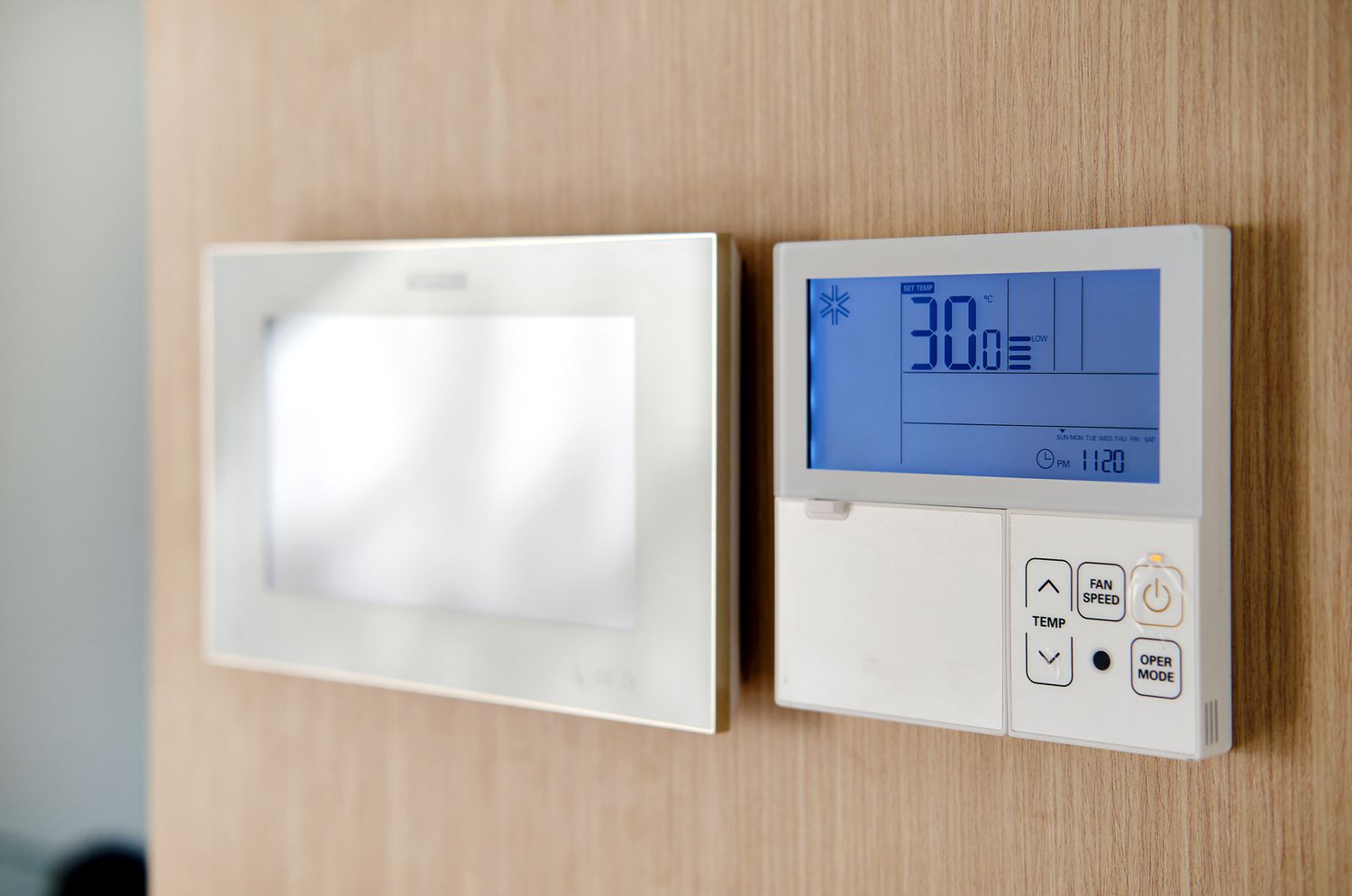 Thermostat monté sur un mur en finition bois.
