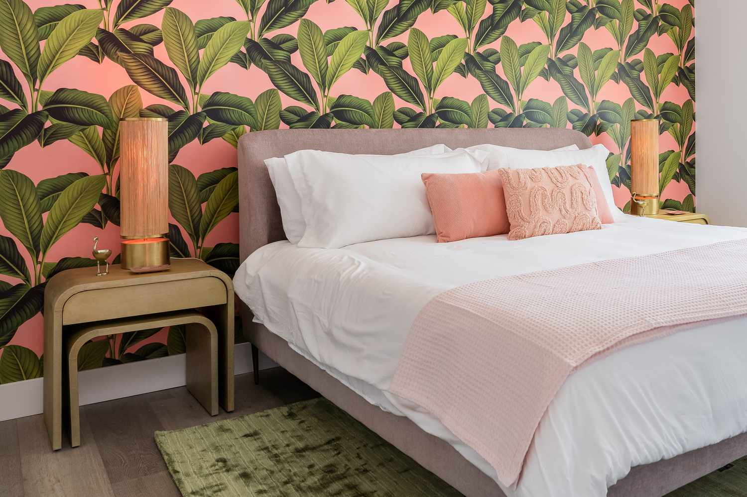 Chambre avec papier peint tropical rose et vert et literie rose