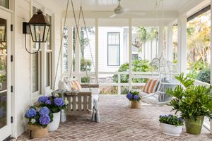 Porche d'été avec chaises suspendues, banc et fleurs d'hortensia