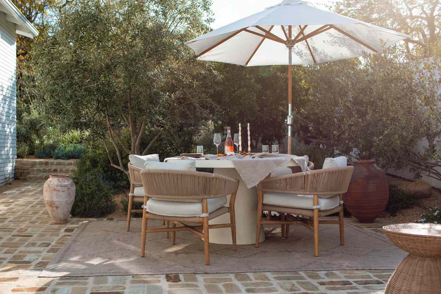 Jardin méditerranéen avec table à manger sur pied et chaises en baril naturelles