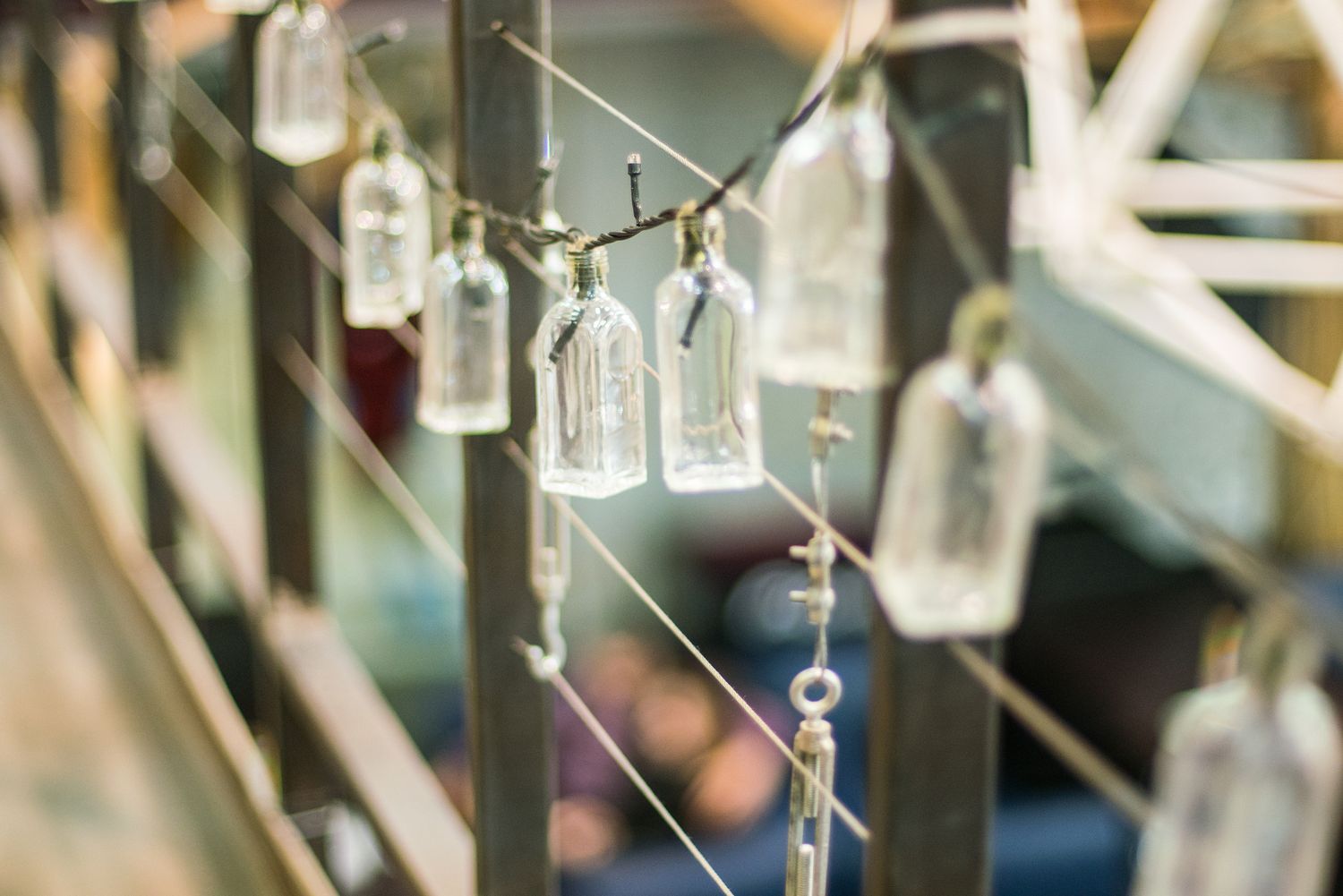 Des bouteilles avec de petites lumières féeriques à l'intérieur suspendues à un garde-corps