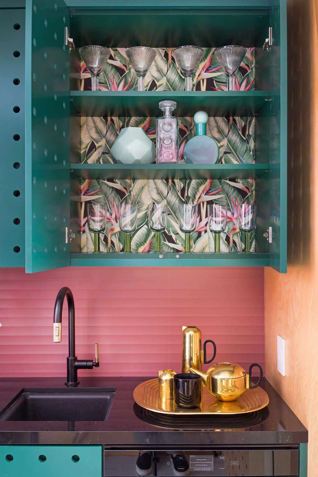 Leaf print wallpaper on the inside of a kitchen cabinet