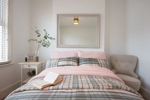 White bedroom with pink and plaid bedding