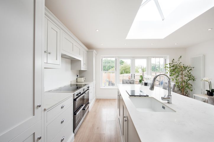 Clean white kitchen with white cabinets and stainless steel appliances