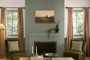 green living room with green velvet chairs and plaid curtains