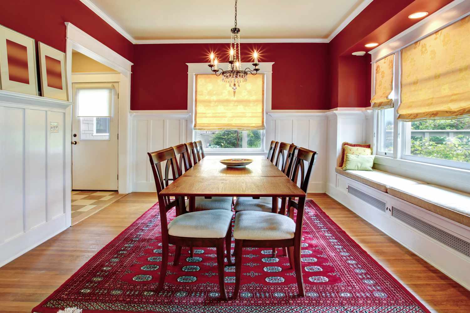 Salle à manger avec un mur peint en rouge profond