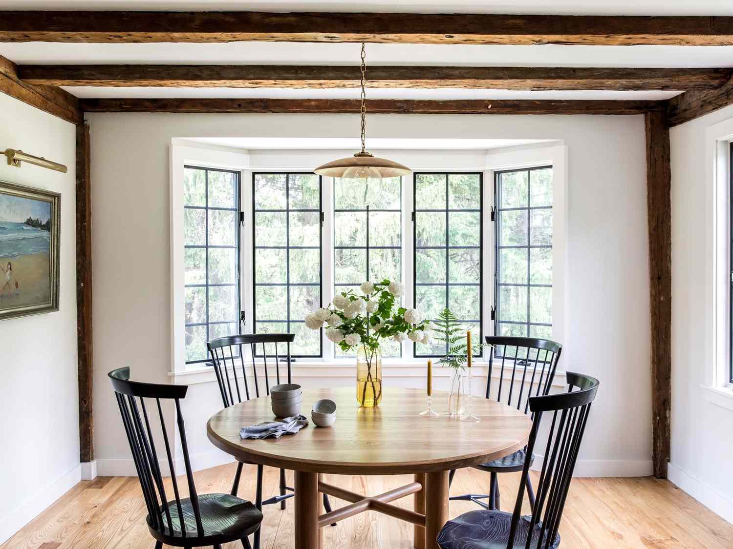White dining room with exposed wooden beams