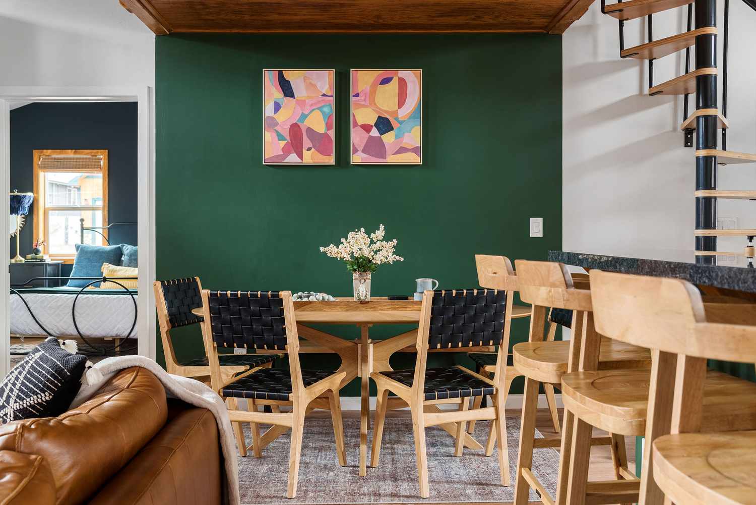 Front view of a dining room nook with an emerald green accent wall