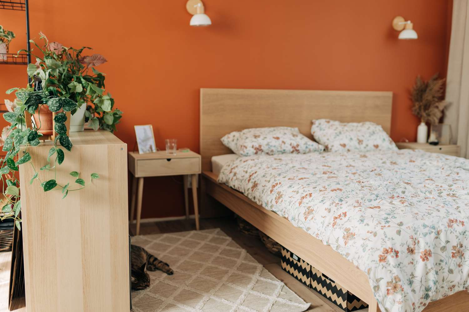 Chambre peinte en orange avec literie à motifs floraux
