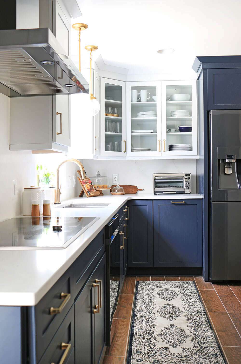 A kitchen with white upper cabinets and blue lower cabinets