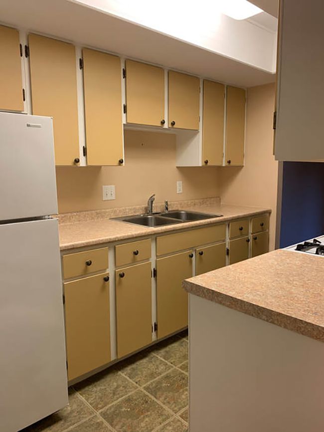 An outdated kitchen with yellow cabinets