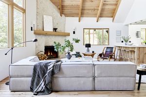 Salon avec plafond à panneaux de bois et canapé gris